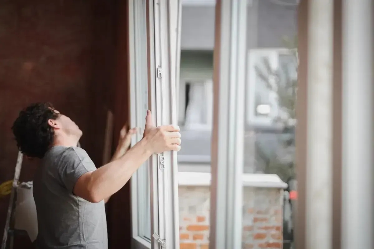 a-young-man-installs-a-window-frame