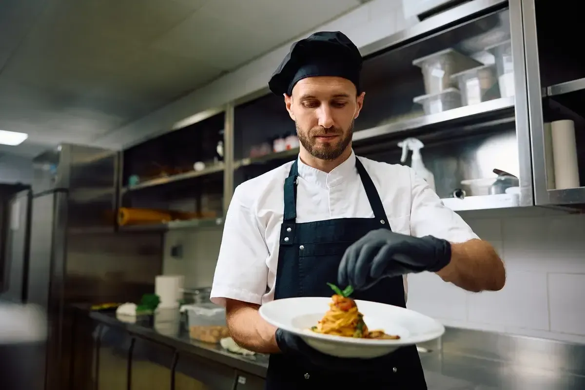 male-chef-finishing-a-dish-while-cookin