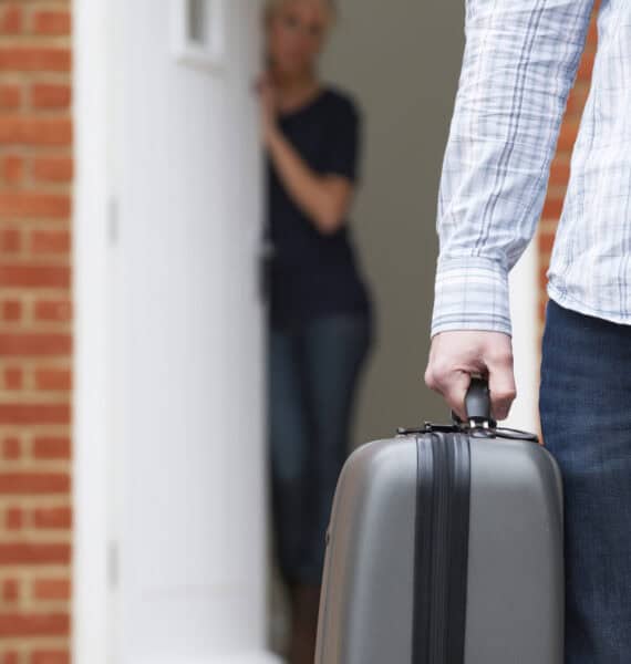 Un homme tenant une valise après s'être séparé de sa partenaire.