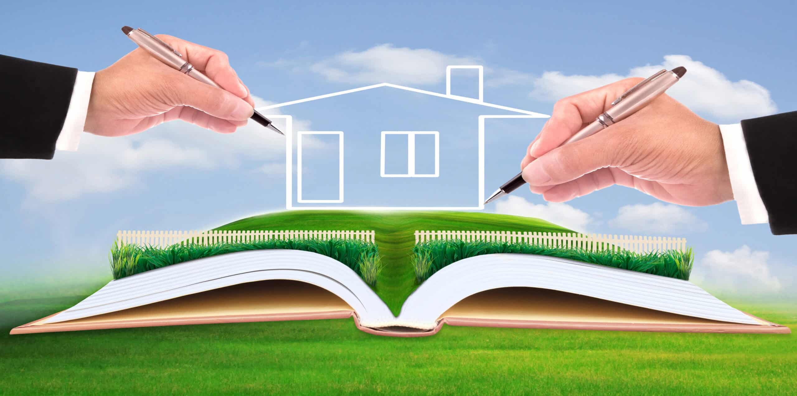 Deux mains dessinant les contours d'une maison au-dessus d'un livre ouvert avec un paysage herbeux, symbolisant le concept de terrain devenu constructible ou de conception architecturale.