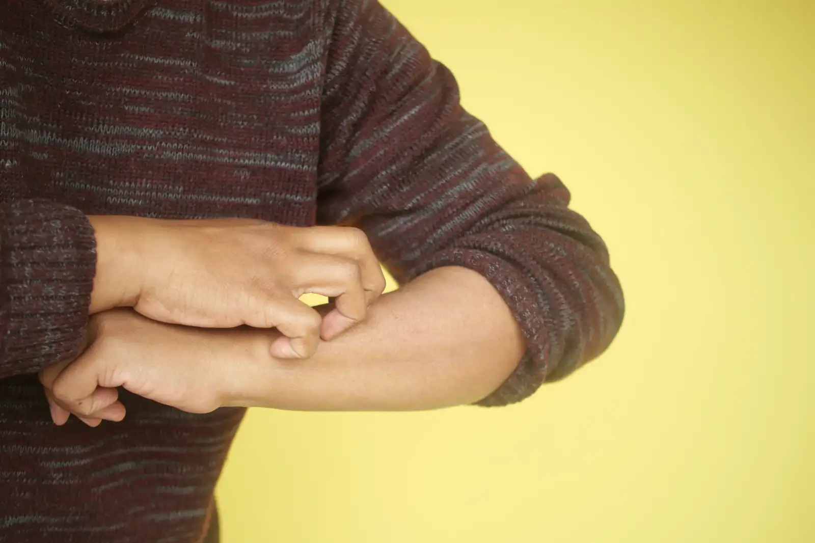 man scratching from bug bites