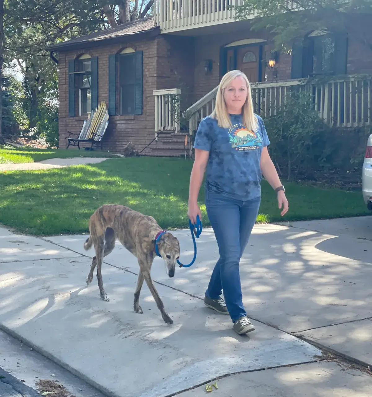 Owner walking her dog on a loose leash outside their home Owner walking her dog on a loose leash outside their home