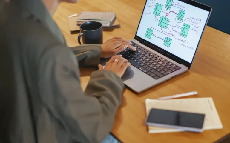 professional-working-on-laptop-at-wooden