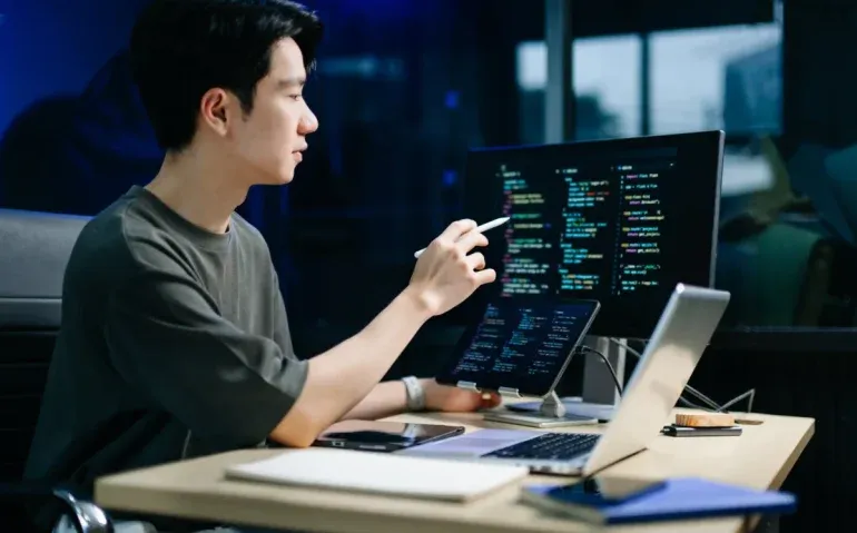young-man-coding-with-tablet-and-laptop