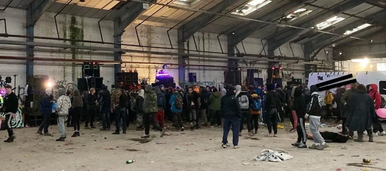 A raw, unadvertised warehouse rave capturing the essence of finding underground electronic music events in 2026. This image represents the 'off-grid' scene where locations are shared via private community networks rather than mainstream platforms