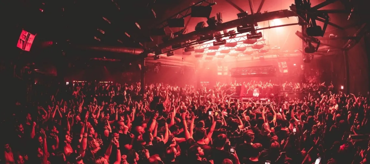 Large crowd at a Unreal Germany with industrial lighting, representing the global scale of the hard techno movement and current industry crisis.