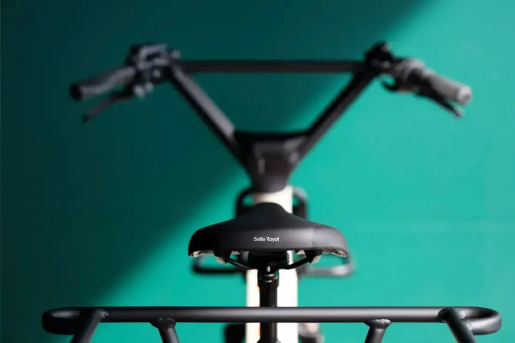 Primer plano del asiento y el manillar de una bicicleta Moustache Lundi 20 Cargo sobre un fondo verde, con "Selle Royal" en el asiento.