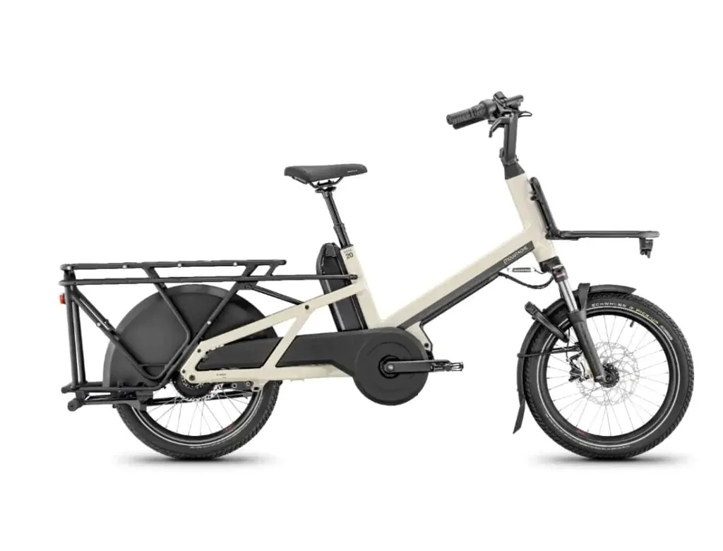 Una moderna bicicleta eléctrica Moustache Lundi 20 Cargo con un cuadro beige, neumáticos negros y un portaequipaje trasero, vista de lado.