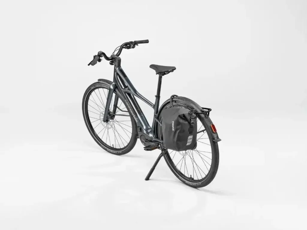 Bicicleta urbana Cannondale FlyingV negra con bolsa trasera, sobre fondo blanco.