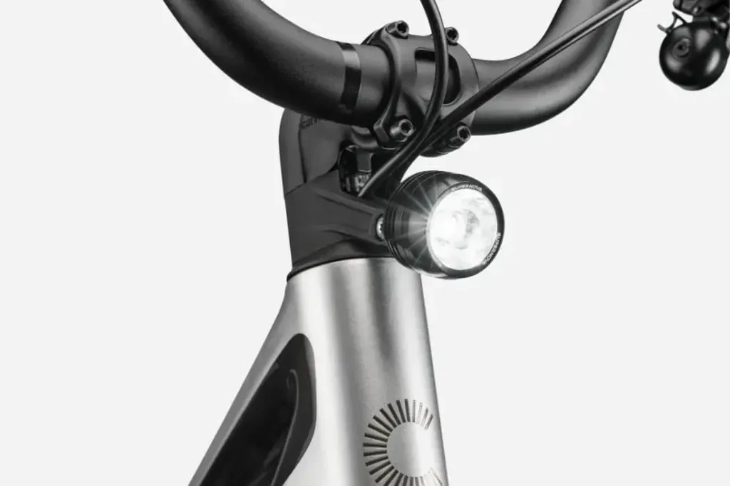 Primer plano del manillar y el cuadro de una bicicleta Cannondale FlyingV con un brillante faro delantero encendido.