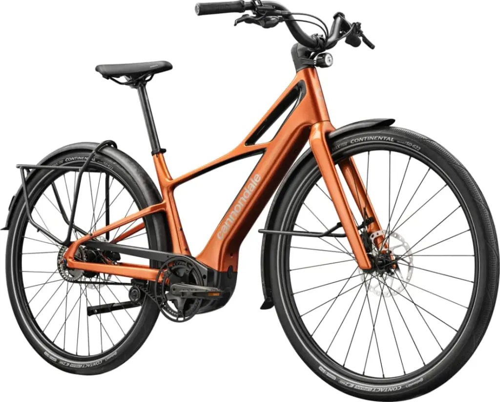 Bicicleta eléctrica Cannondale naranja con neumáticos y guardabarros negros, vista desde la parte delantera izquierda.
