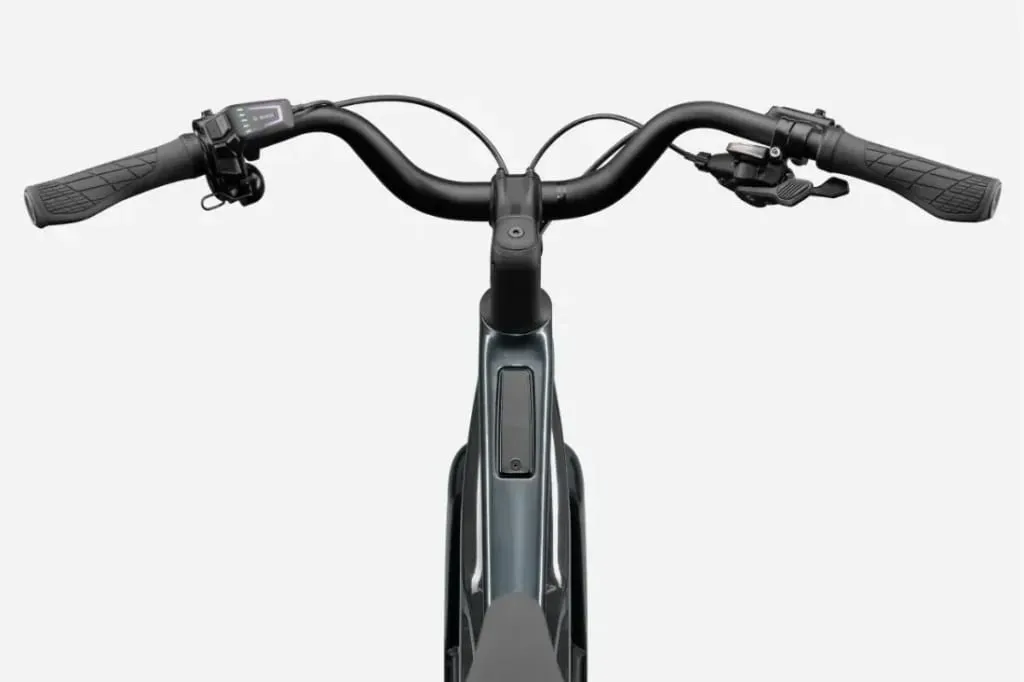Primer plano de un manillar de bicicleta Cannondale FlyingV negro con puños, frenos y una pequeña pantalla digital a la izquierda.