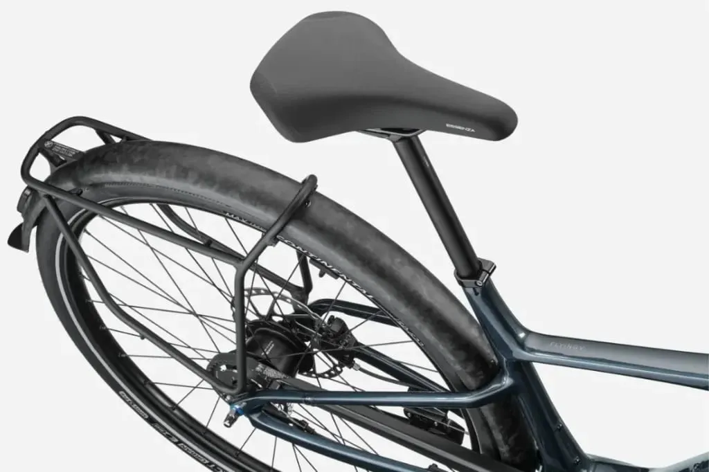 Primer plano de la sección trasera de una bicicleta Cannondale FlyingV en el que se aprecian el sillín, el portabultos trasero y la cubierta sobre un fondo blanco.