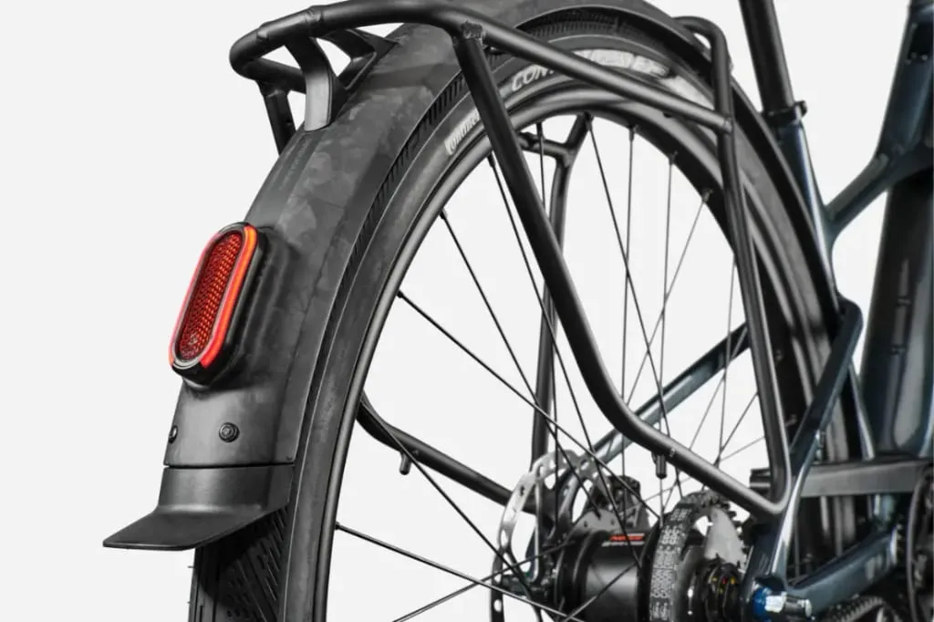 Primer plano de la rueda trasera de una Cannondale FlyingV, destacando el guardabarros, la luz trasera y el detallado mecanismo del cambio.