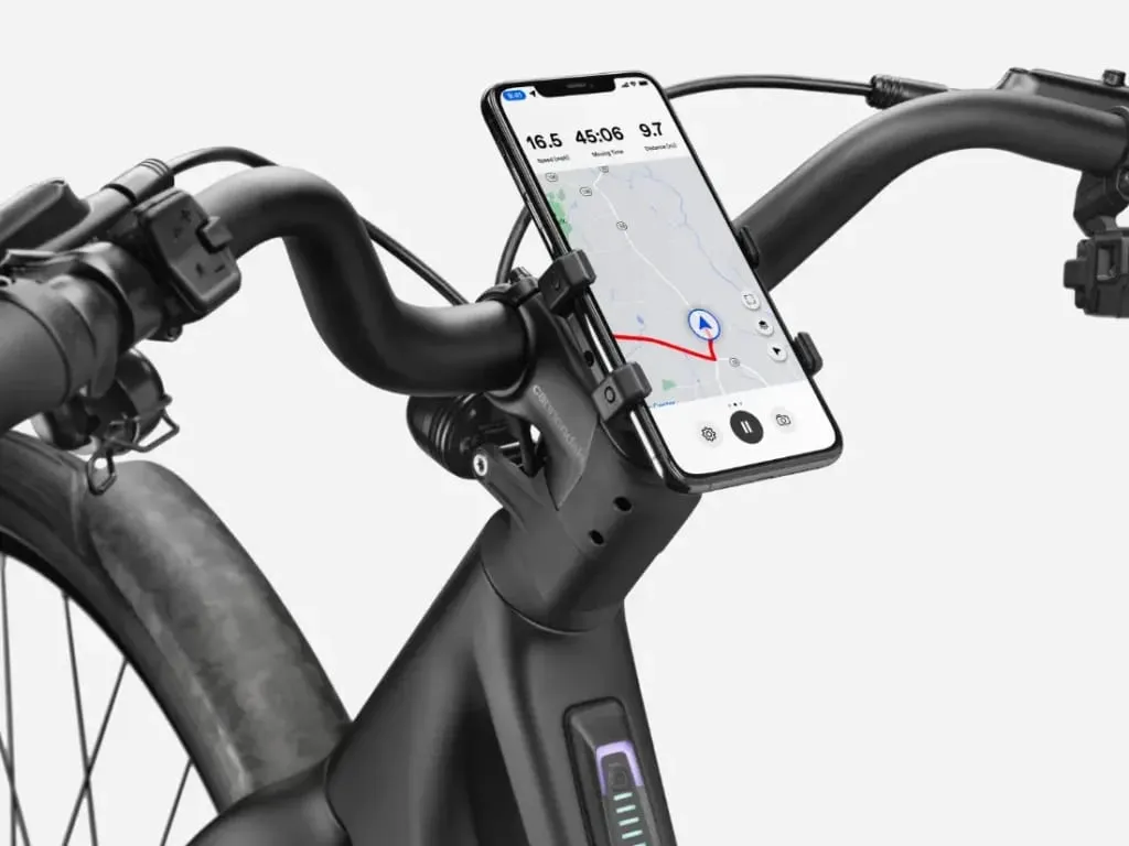 En el manillar de una bicicleta eléctrica negra hay un smartphone con una aplicación cartográfica.
