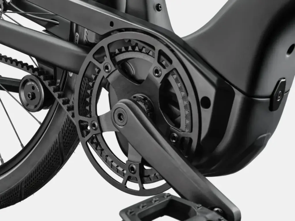 Primer plano de las bielas, el plato y los pedales negros de una bicicleta eléctrica.