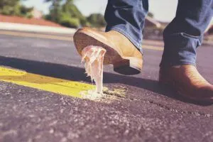 Bota con chicle pegado en la suela sobre asfalto junto a una línea amarilla; ¿Por qué todo me sale mal según la Biblia? Descubre la respuesta aquí