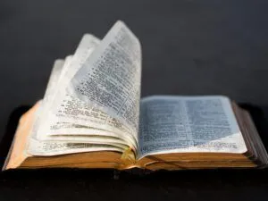 Open Bible with delicate, translucent pages fanned and a ribbon marker, photographed in close-up to illustrate World War II in the Bible: Uncovering Surprising References.