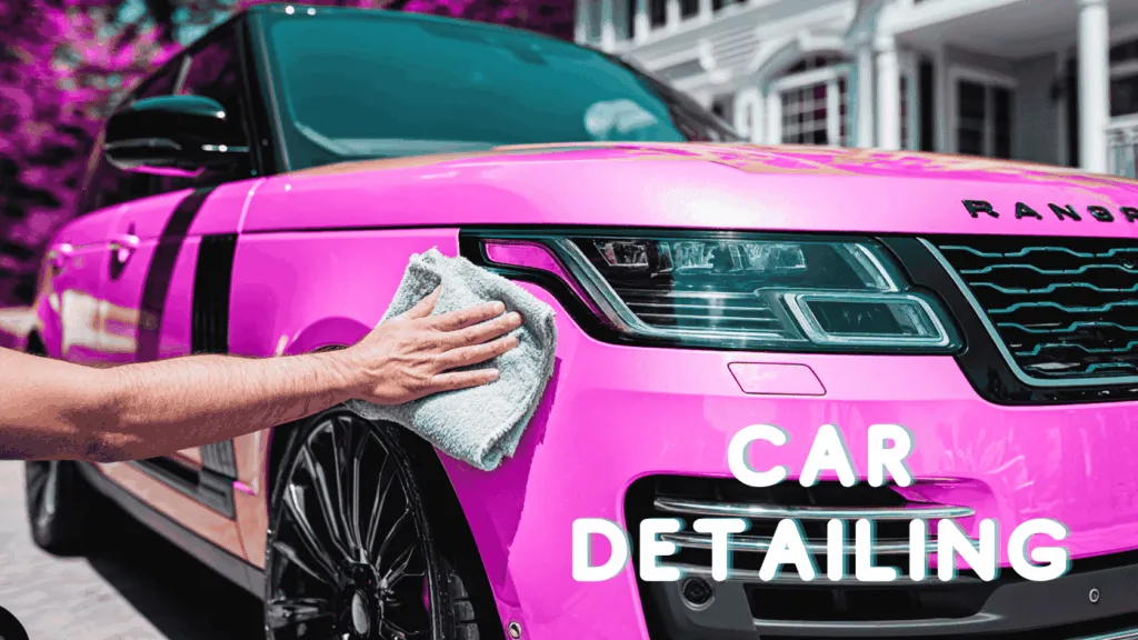 Person polishing a luxury SUV during a mobile car detailing service with a bright pink finish in front of a suburban home