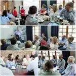 Team coaching session with a group of professionals engaged in presentations and discussions in a conference room setting.