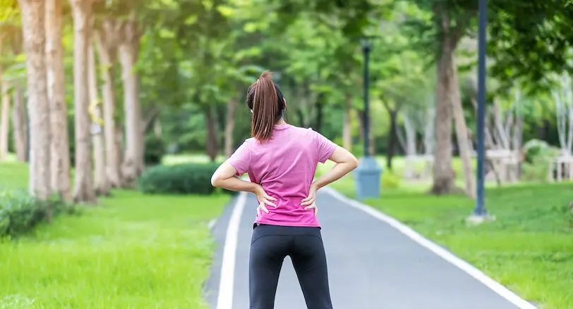 Young adult female with his muscle pain during running. runner woman having back body ache due to Piriformis Syndrome, Low Back Pain and Spinal Compression. Sports injuries and medical concept