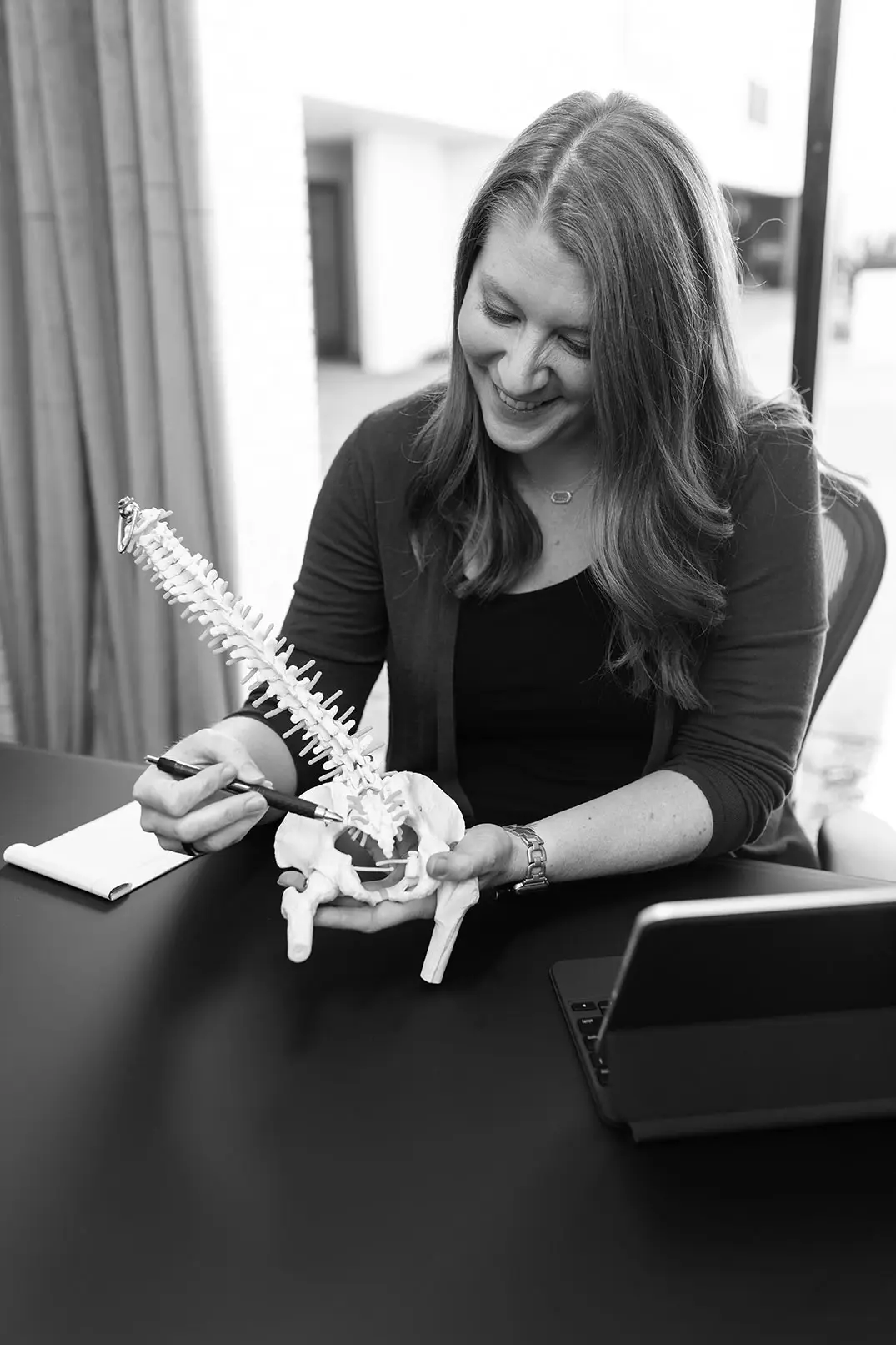 Physical therapist explaining the spine using an anatomical model
