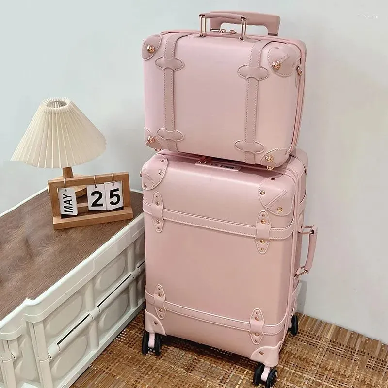 Rosa resväskor i vintagestil i två olika storlekar staplade på varandra