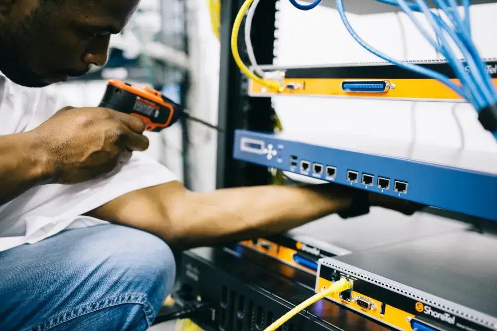 Technician setting up office network equipment for IT support in JVC Dubai