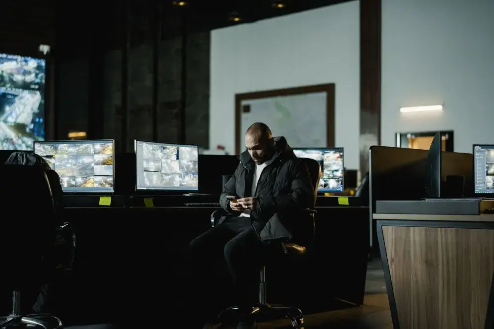 Office manager reviewing live CCTV security system footage on a desktop monitor