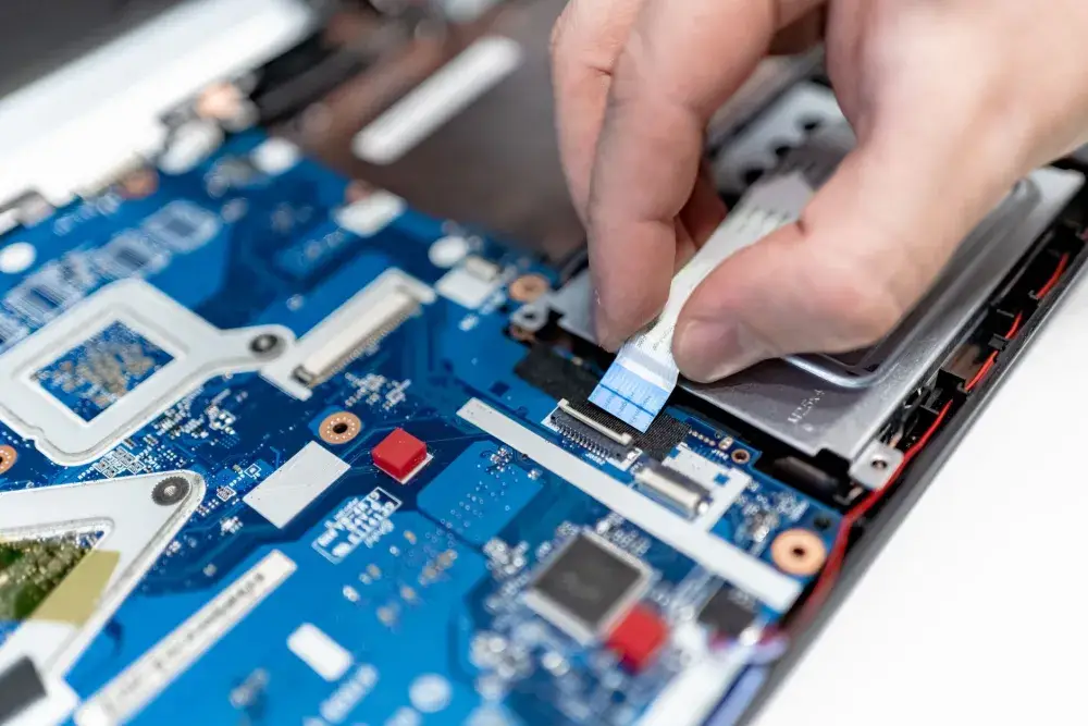 IT technician repairing a laptop on-site under an annual IT maintenance contract