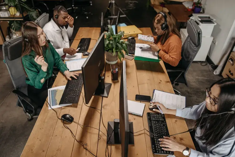 Office team resuming work on computers after successful emergency IT troubleshooting in Downtown Dubai