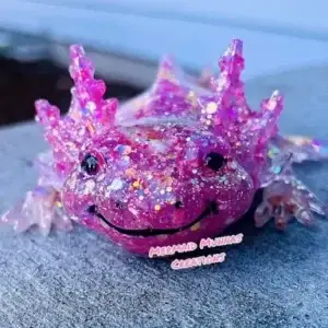 Smiling pink and purple glitter resin axolotl figurine.