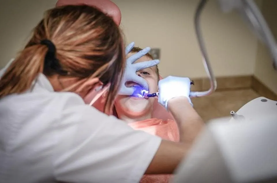 Dentist using a curing light during a tooth-colored restoration