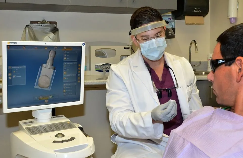 Dentist examining a patient in the chair, the first step in deciding whether a chipped crown can be repaired