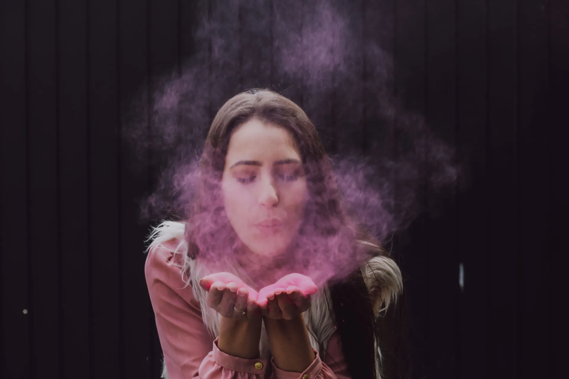 woman blowing smoke on her both hands