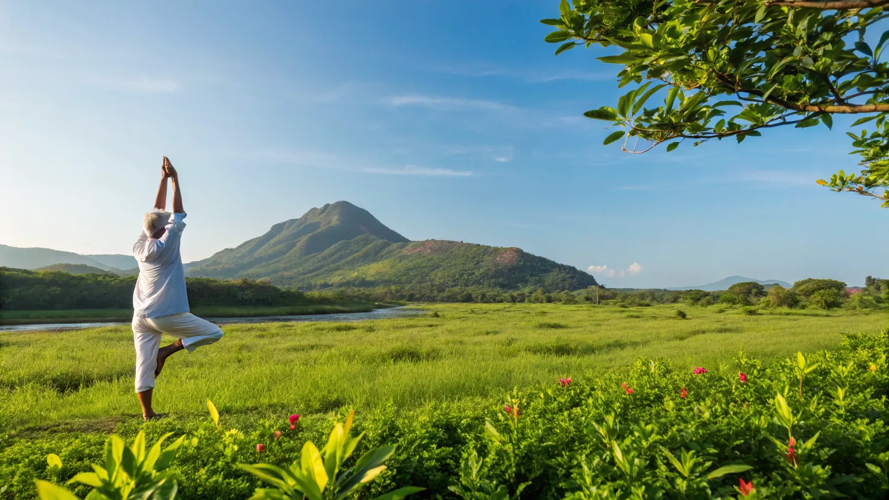 Eine Person praktiziert Yoga auf einer Wiese mit grünem Gras und Sträuchern, mit Blick auf einen Berg unter einem klaren blauen Himmel, und genießt dabei ihr Wohlbefinden und die Vorteile von Magnesium für das Gleichgewicht von Körper und Geist.