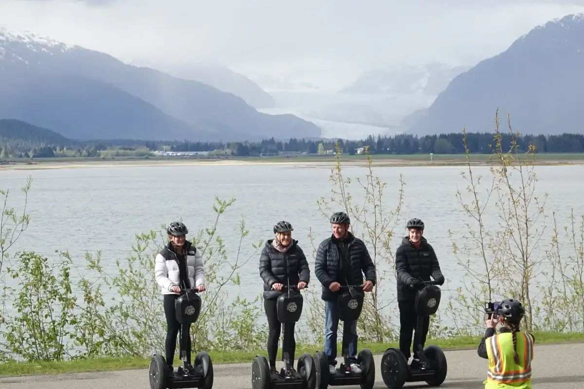 Best Juneau Shore Excursions for Cruise Passengers: Top Tours 2 Four people on a Juneau Segway tour with Mendenhall Glacier and coastal mountains.