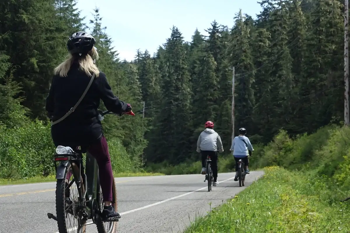 Juneau E-Bike Tours for Cruise Passengers | iRide Alaska 2 Three people on a Juneau eBike tour ride bikes through a coastal forest.