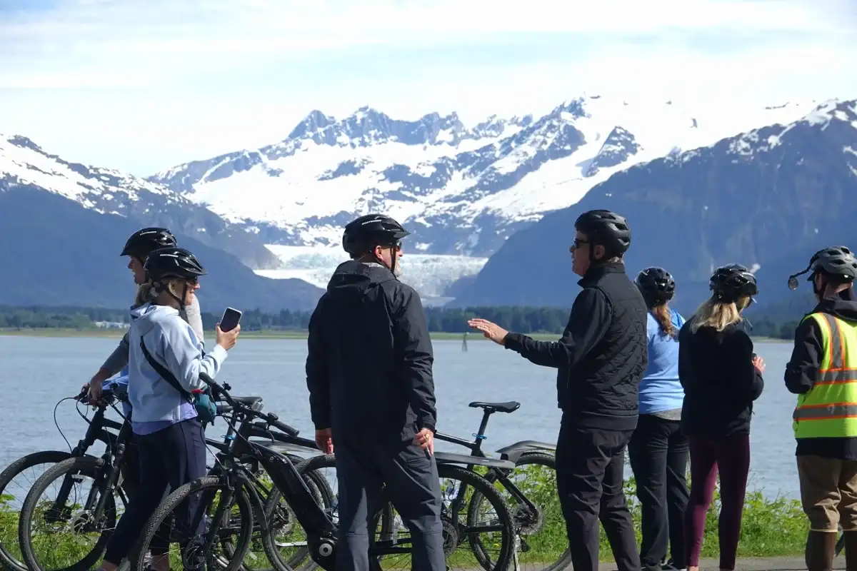 Juneau eBike tour group with a guide, overlooking Mendenhall Glacier and mountains.