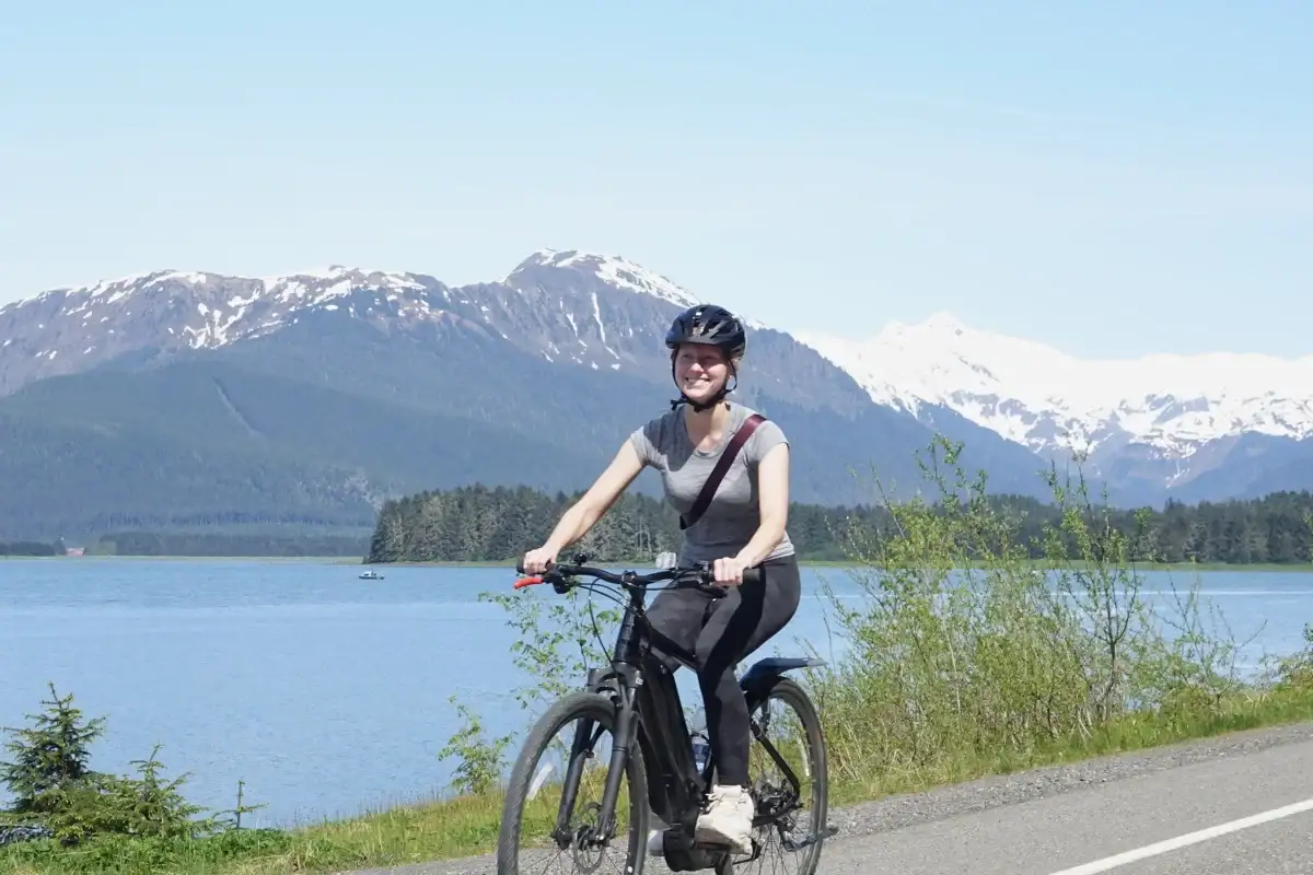 Juneau E-Bike Tours for Cruise Passengers | iRide Alaska 3 Happy woman on a Juneau eBike tour with snow-capped mountains and water.