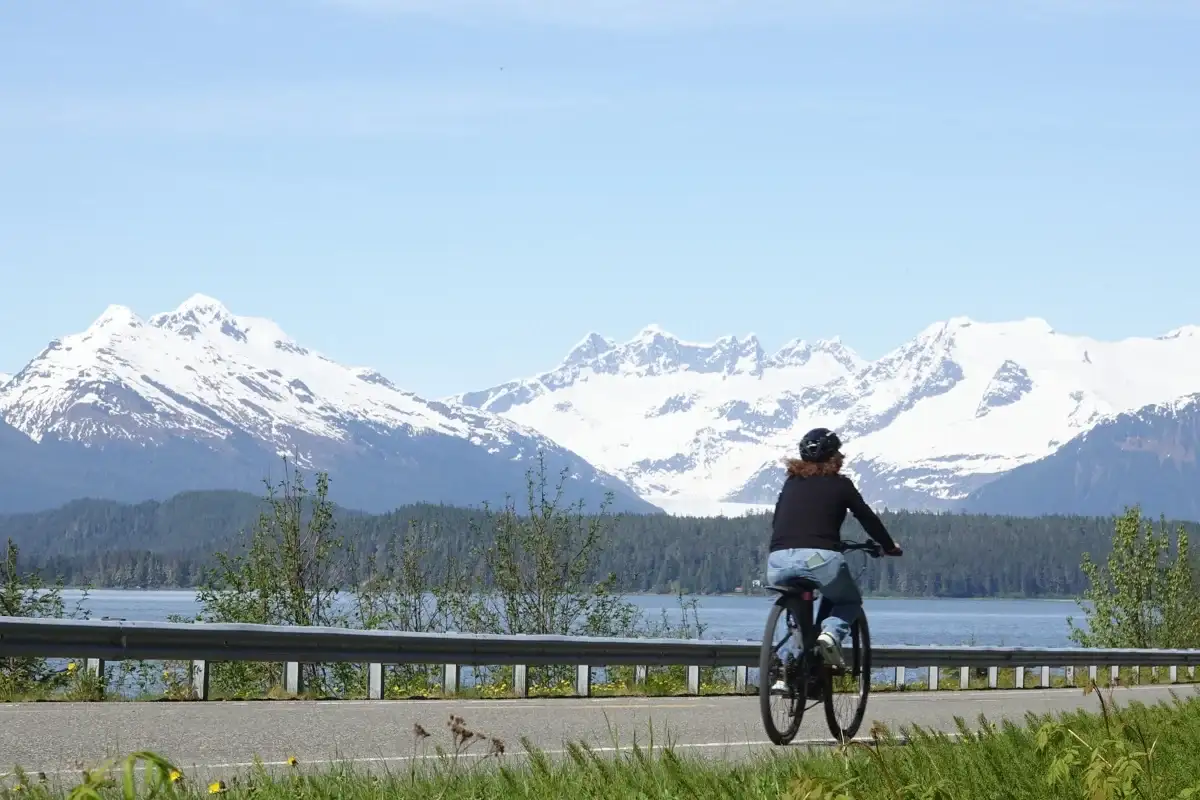 Best Juneau Shore Excursions for Cruise Passengers: Top Tours 3 Rider on a Juneau eBike tour with snow-capped mountains and coastal forest.