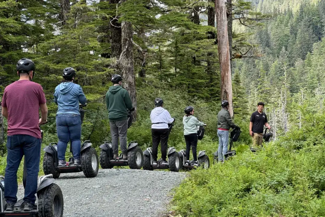 Segway Tour Requirements: Weight, Age & Safety | iRide Alaska 2 Juneau Segway tour guests with a guide on a gravel trail in a lush rainforest.