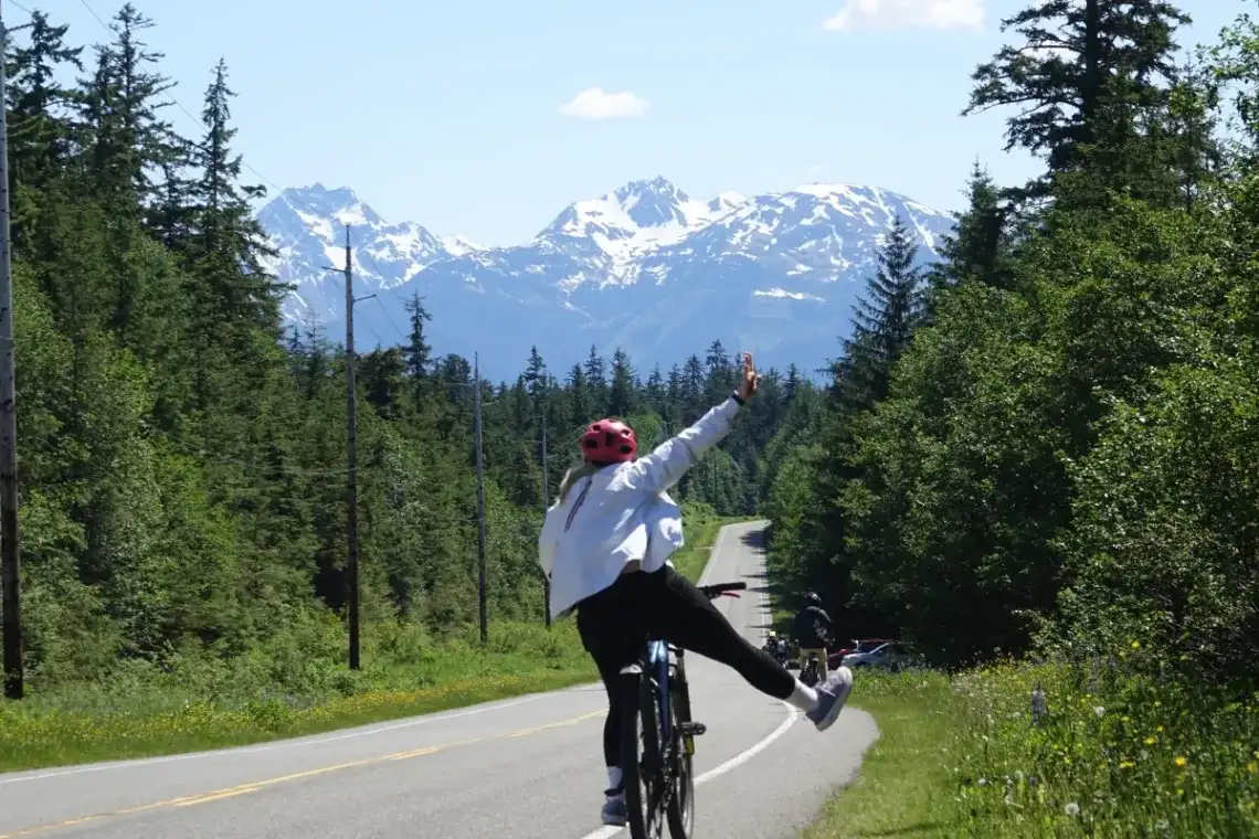 The Quiet Side of Juneau: Why E-Bike Tours Beat the Van 2 Person on an eBike tour in Juneau, Alaska, with dense forest and snow-capped mountains.