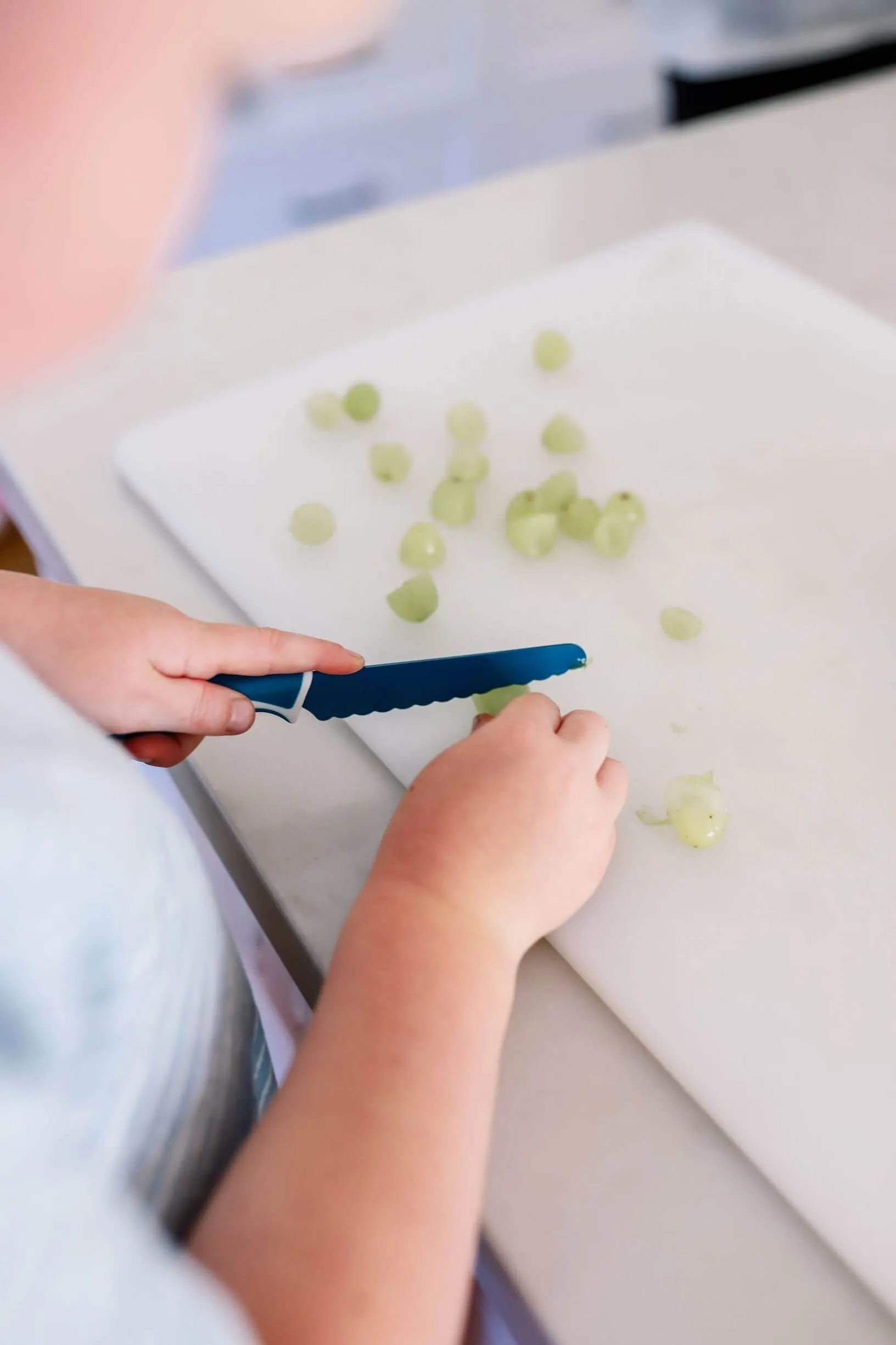 Child cutting vegetables with a KiddiKutter knife