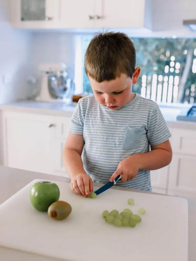 Boy cutting vegetables with a Charcoal KiddiKutter