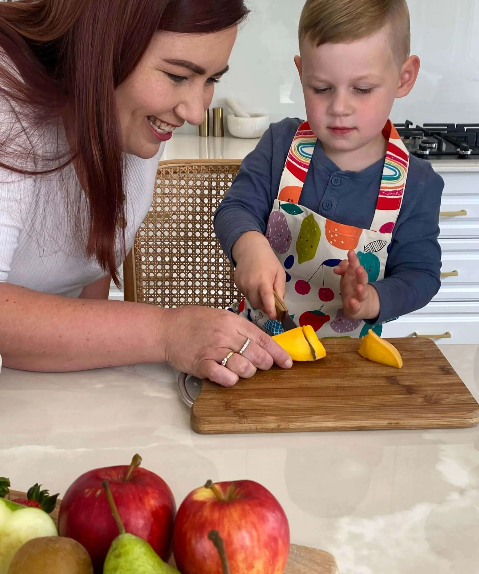 Parent and child cutting vegetables with a wooden handled KiddiKutter