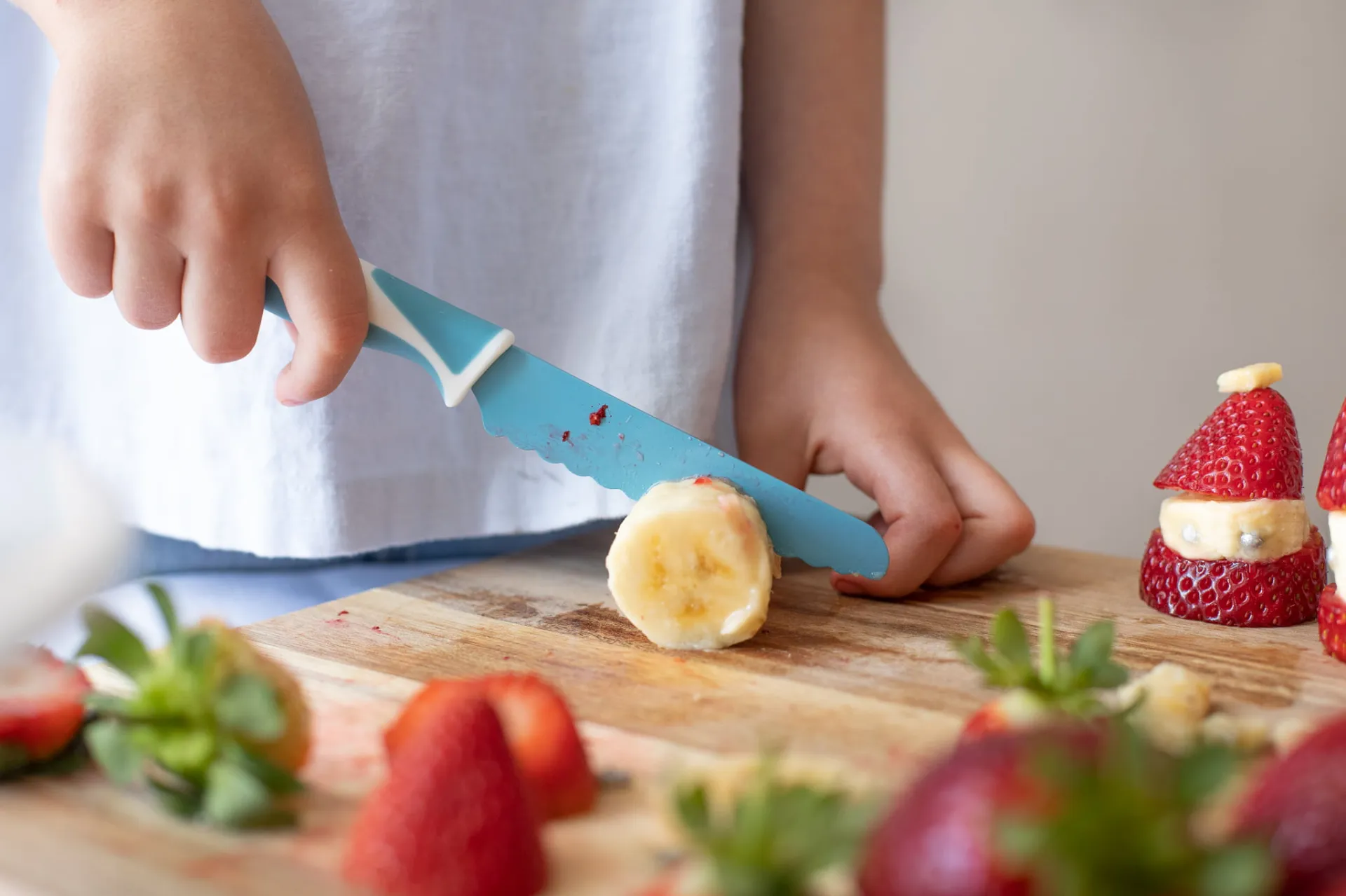 Child cutting a lemon with a Sky Blue KiddiKutter