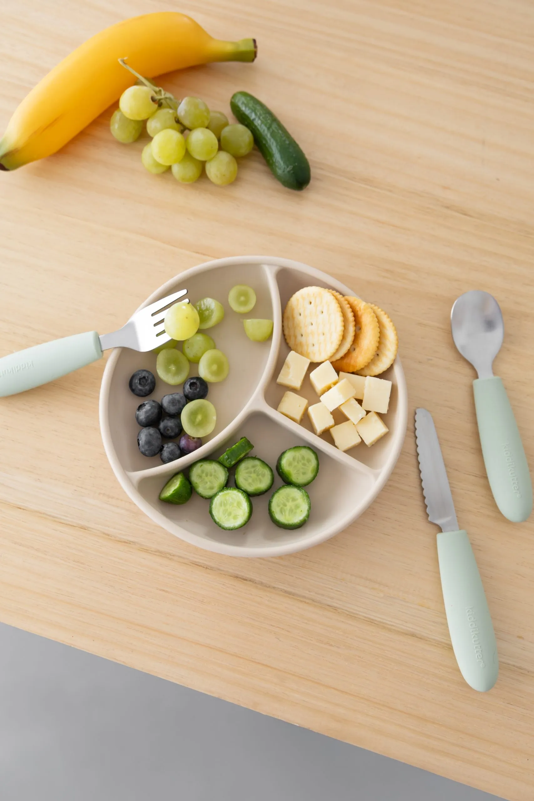 Kids cutlery set with a divided plate of snacks