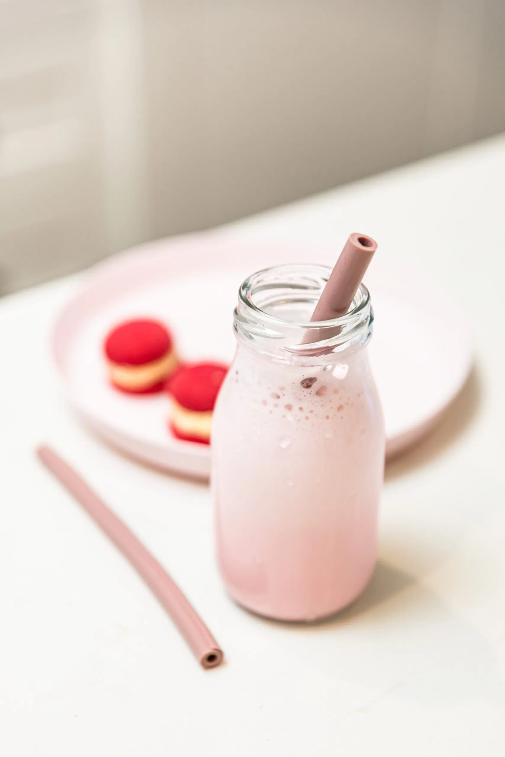 Strawberry smoothie with a pink silicone straw