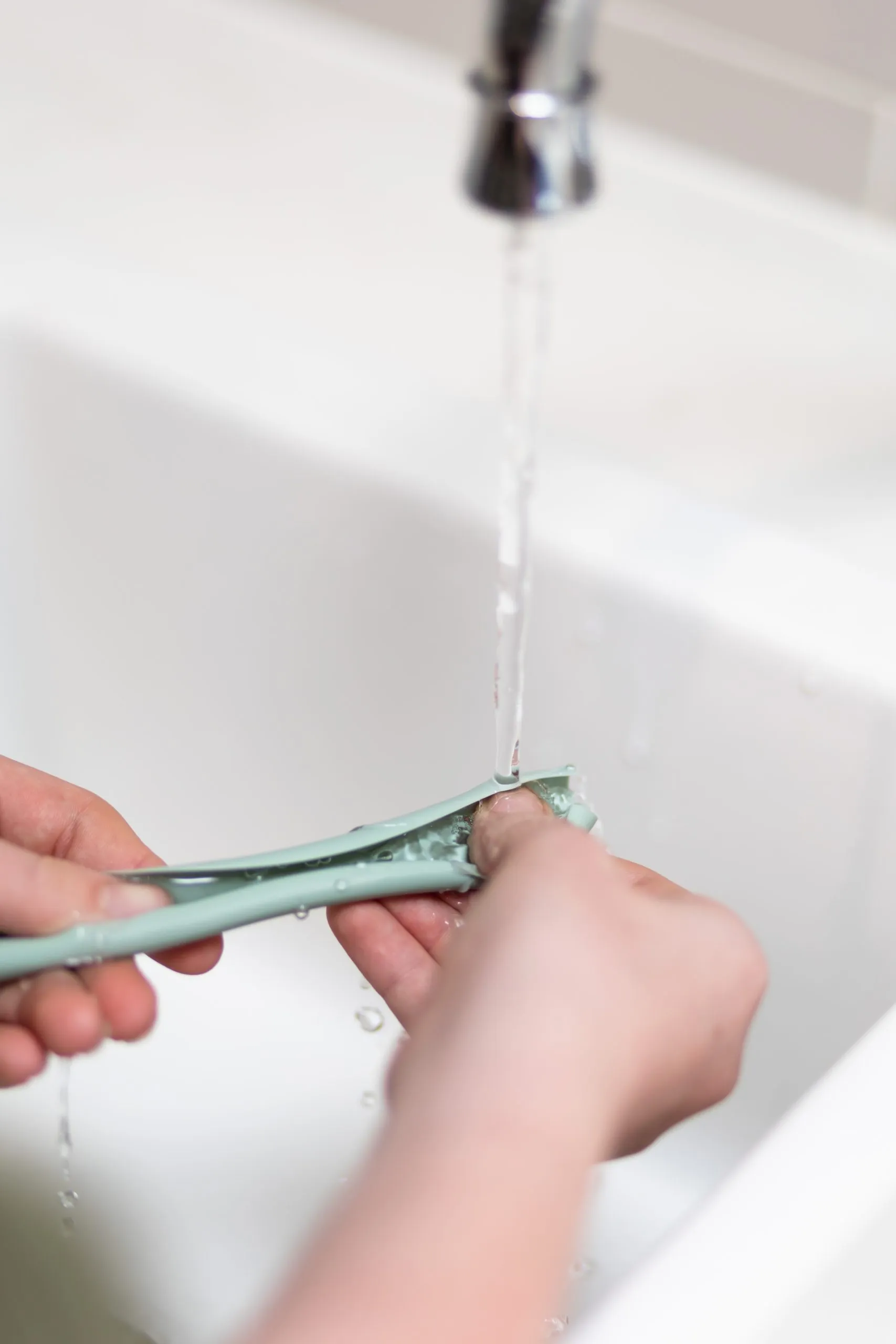 Rinsing a Flex & Roll silicone straw under the tap